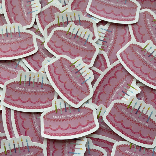 A pile of die-cut stickers shaped like pink birthday cakes with white borders and colorful candles, each printed with the phrase 'have a kickass birthday!'.