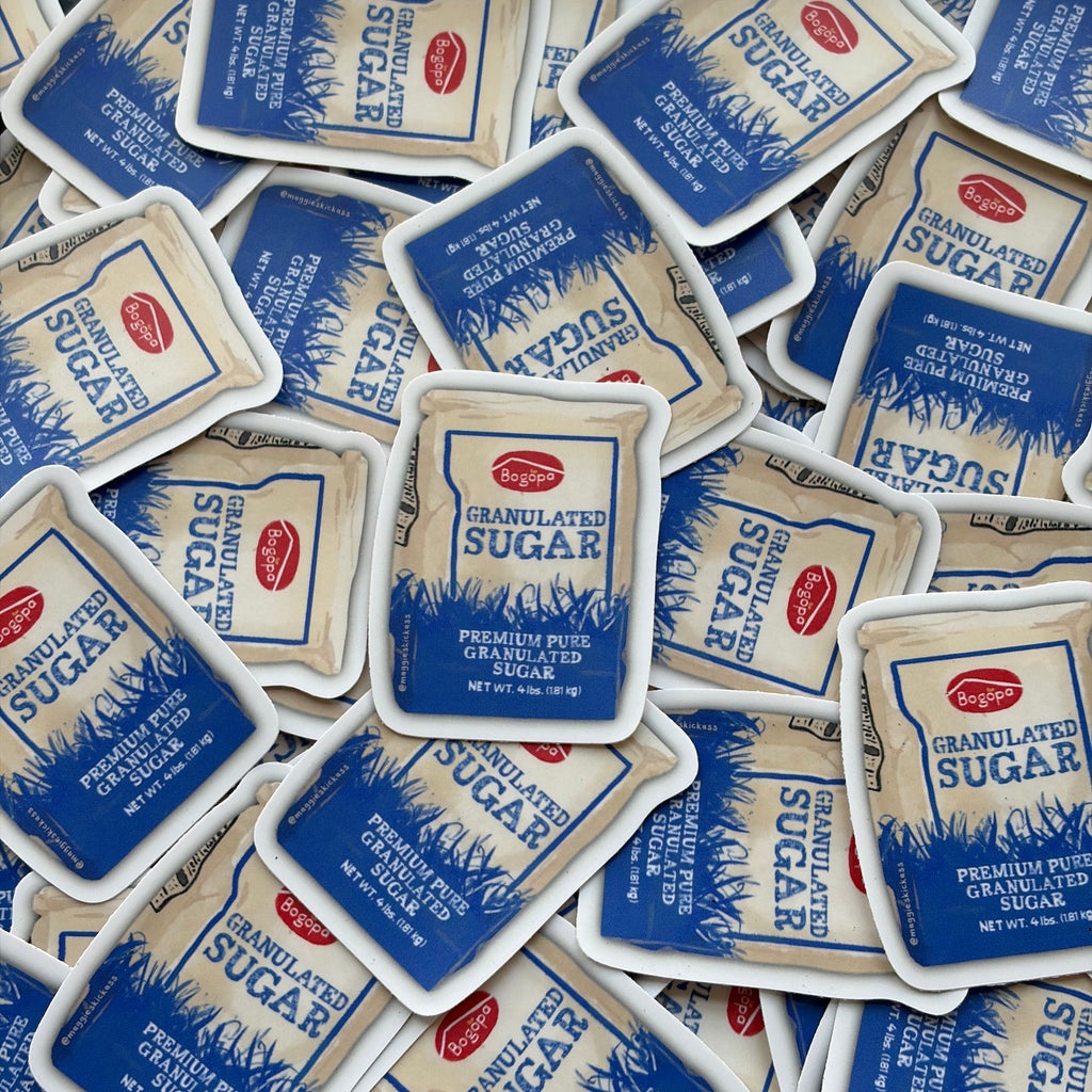 A pile of Bogopa Granulated Sugar bag stickers spread across the frame, showing the blue and white packaging with the red Bogopa logo.